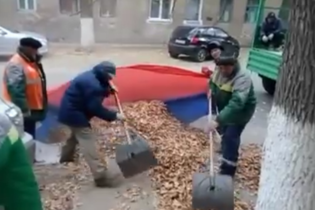 Суровые волгоградские дворники сгребают листья в российский флаг