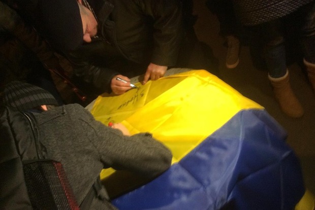 Українці в аеропорту підписують прапори з побажаннями звільненим військовополоненим