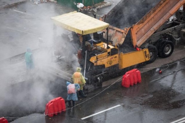 Дорожники у столиці кладуть асфальт під проливним дощем